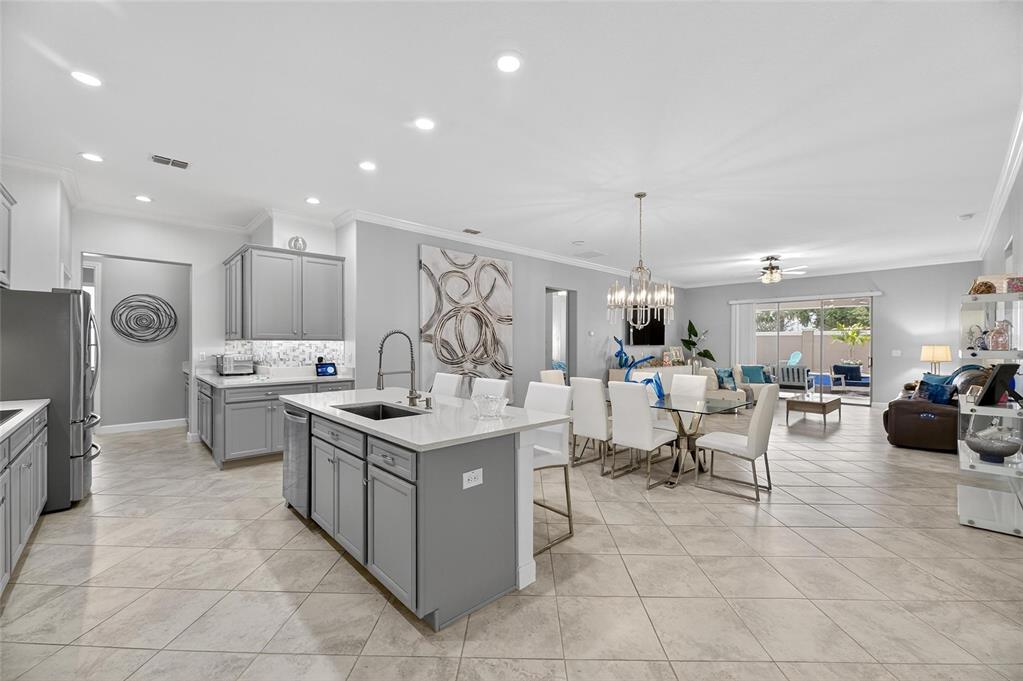 16805 Banner Shell Place Wimauma, FL 33598 - Photo 13 of 44 a kitchen with stainless steel appliances granite countertop a sink and a refrigerator