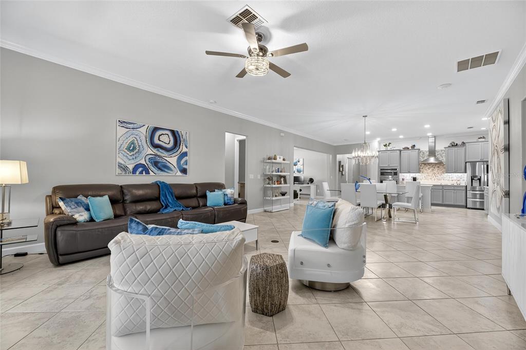 16805 Banner Shell Place Wimauma, FL 33598 - Photo 16 of 44 a living room with furniture and a chandelier