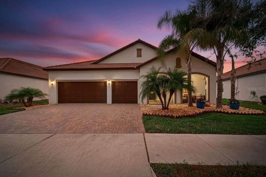 16805 Banner Shell Place Wimauma, FL 33598 - Photo 2 of 44 a view of a house with a yard and palm trees