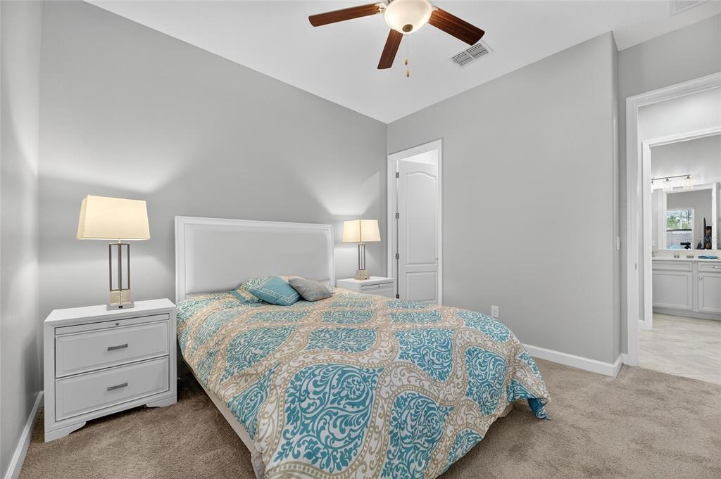 16805 Banner Shell Place Wimauma, FL 33598 - Photo 26 of 44 a bedroom with a bed and a lamp