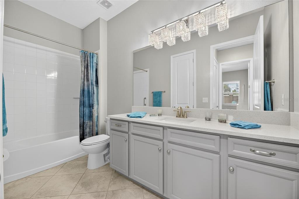 16805 Banner Shell Place Wimauma, FL 33598 - Photo 27 of 44 a bathroom with a double vanity sink mirror and toilet