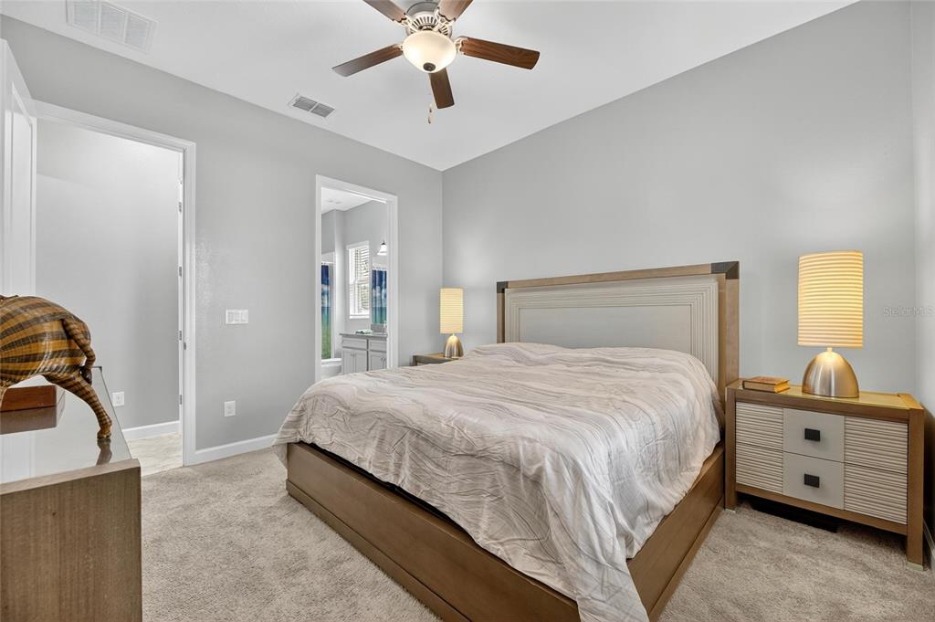 16805 Banner Shell Place Wimauma, FL 33598 - Photo 28 of 44 a bedroom with a large bed and a chandelier