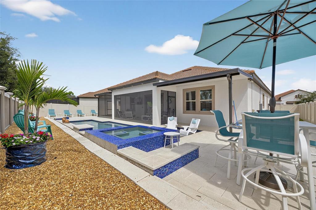 16805 Banner Shell Place Wimauma, FL 33598 - Photo 42 of 44 a patio with a table and chairs under an umbrella
