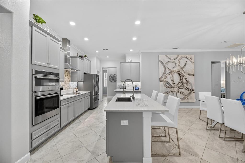 16805 Banner Shell Place Wimauma, FL 33598 - Photo 9 of 44 a kitchen with stainless steel appliances kitchen island granite countertop a sink stove and refrigerator