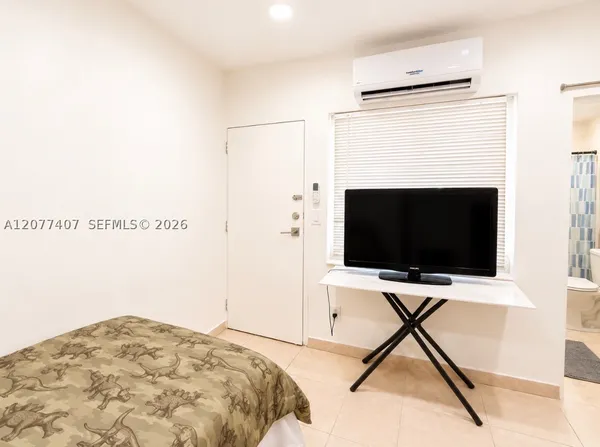 a bedroom with a bed and a flat screen tv
