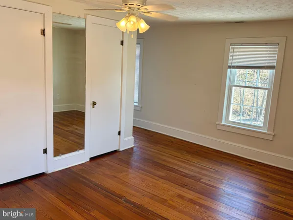 an empty room with wooden floor and a window