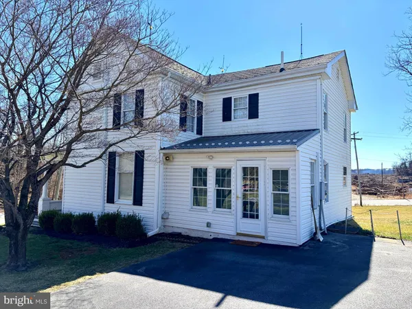 a view of a white house with a large window and wooden floor