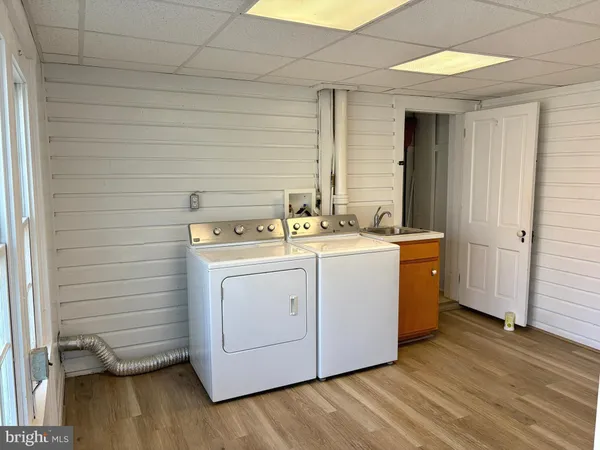 a utility room with wooden floor washer and dryer