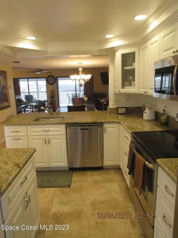 a large kitchen with stainless steel appliances granite countertop a stove a sink and a microwave