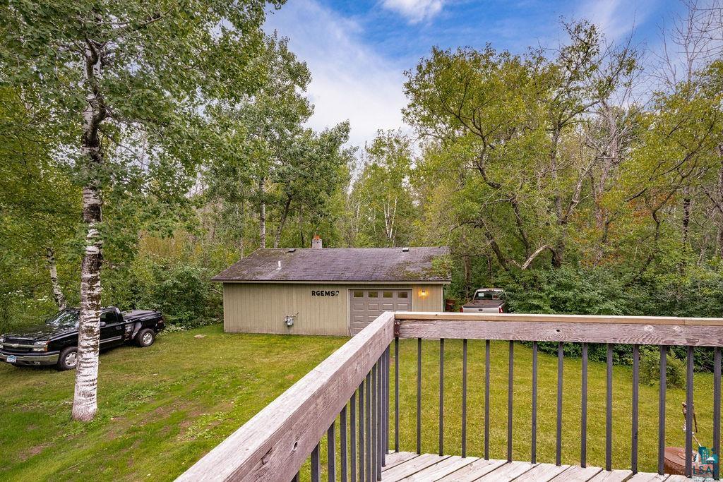 4738 Morris Thomas Road Hermantown, MN 55811 - Photo 3 of 19 Detached garage with an overhead door, surrounded by mature trees and verdant landscaping