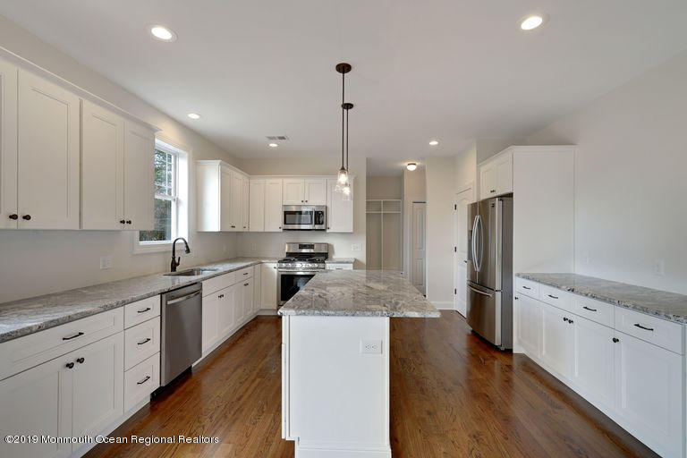 109 Leeward Road Manahawkin, NJ 08050 - Photo 4 of 71 a kitchen with stainless steel appliances kitchen island granite countertop a refrigerator a sink dishwasher a stove and white cabinets with wooden floor