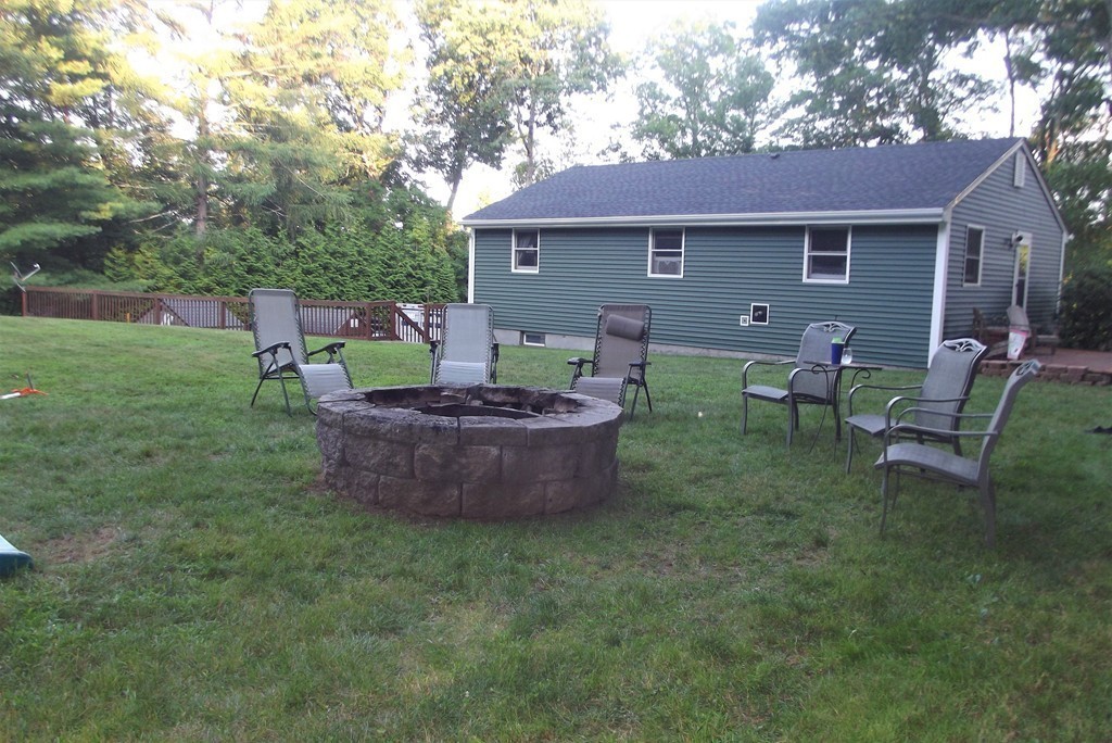 186 Brookfield Road Charlton, MA 01507 - Photo 8 of 28 a view of a backyard with table and chairs and a fire pit