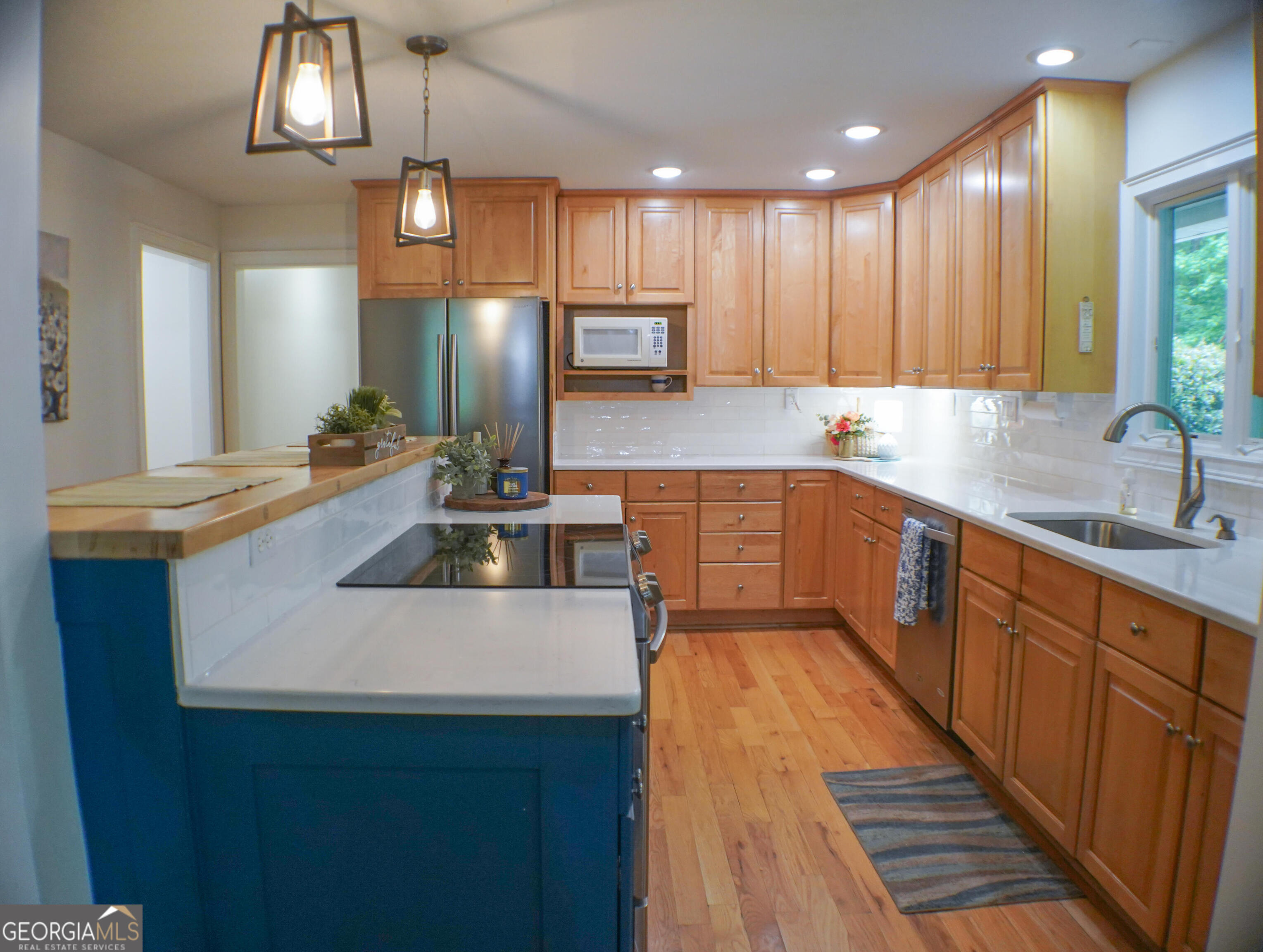 335 Winding Stream Trail Hampton, GA 30228 - Photo 8 of 35 a kitchen with kitchen island granite countertop a sink a counter space appliances and cabinets