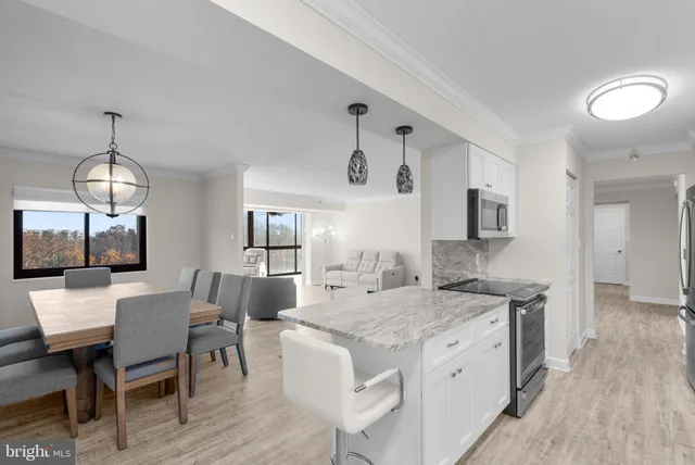 a open kitchen with stainless steel appliances granite countertop a stove and a table chair