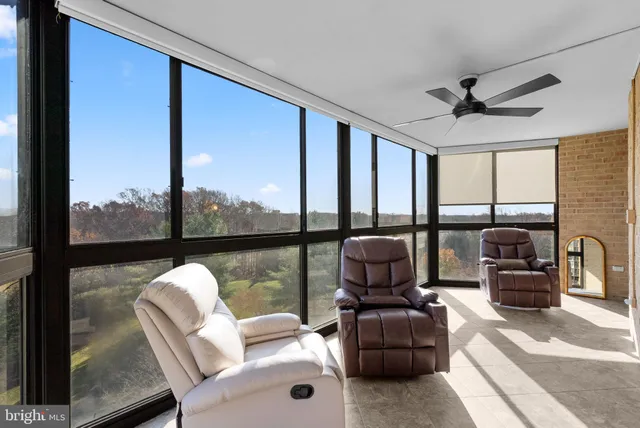 a living room with furniture tv and a floor to ceiling window