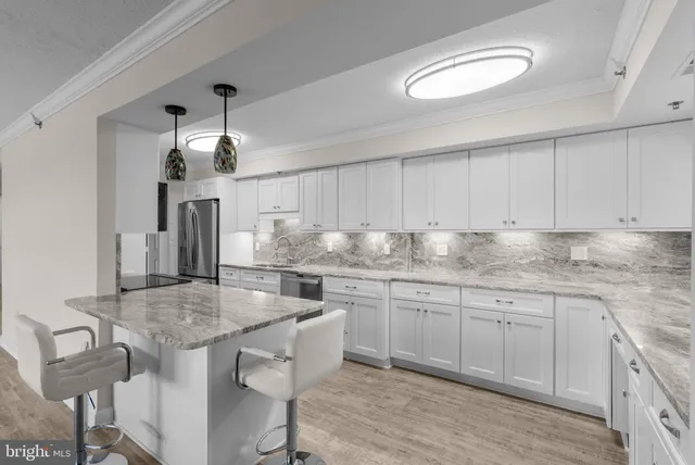 a kitchen with granite countertop a sink and white cabinets