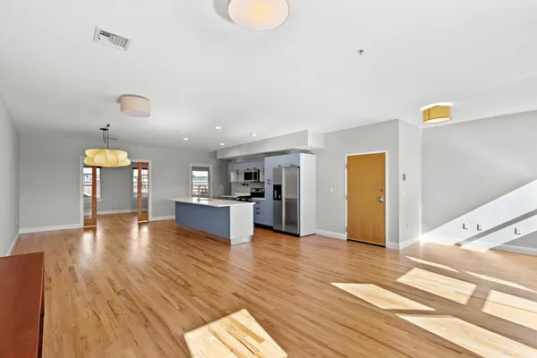 a view of empty room with wooden floor