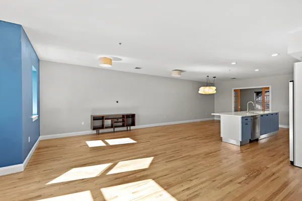 a living room with kitchen island furniture and a wooden floor