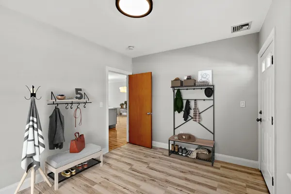 a living room with furniture a flat screen tv and a wooden floor