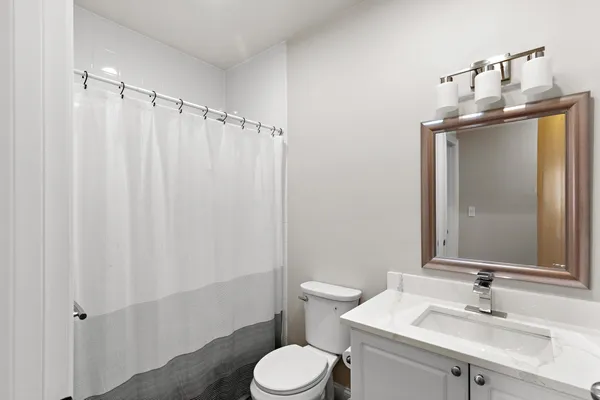 a bathroom with a sink vanity mirror and toilet