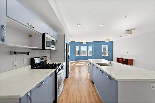 a kitchen with stainless steel appliances a sink stove and cabinets