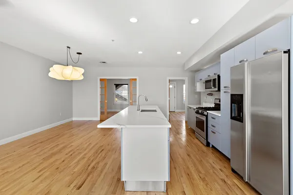 a view of a kitchen with a sink wooden floor and stainless steel appliances
