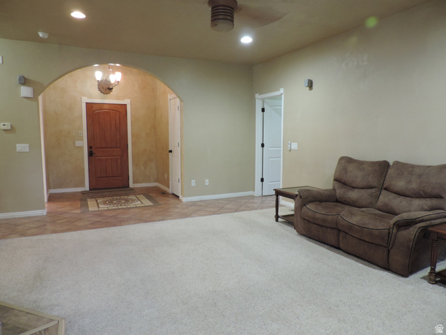 140 North 200 E Street Glenwood, UT 84730 - Photo 3 of 54 Living room with light colored carpet, arched walkways, a chandelier, and ceiling fan