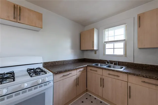 a kitchen with granite countertop cabinets sink and stove