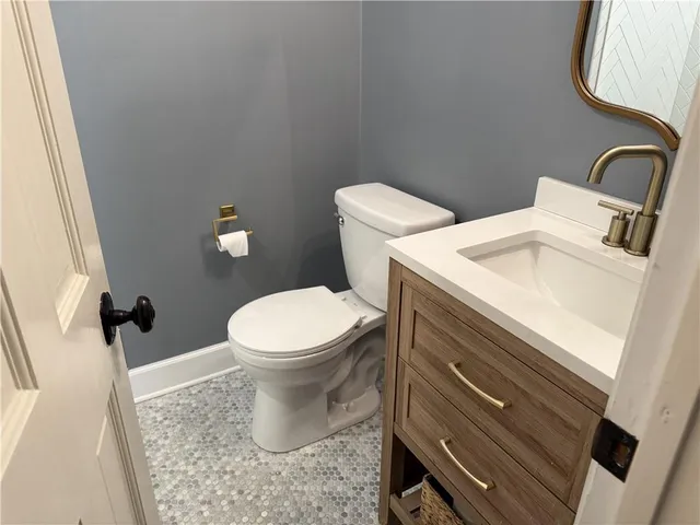 a bathroom with a toilet sink and mirror