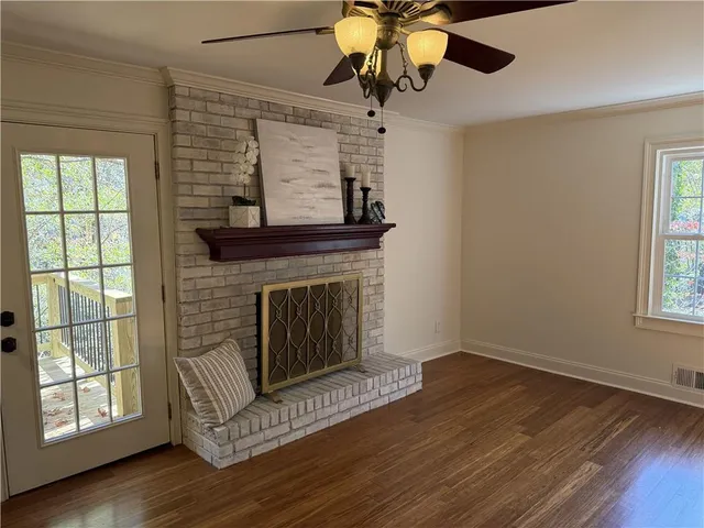 a living room with a fireplace windows and wooden floor