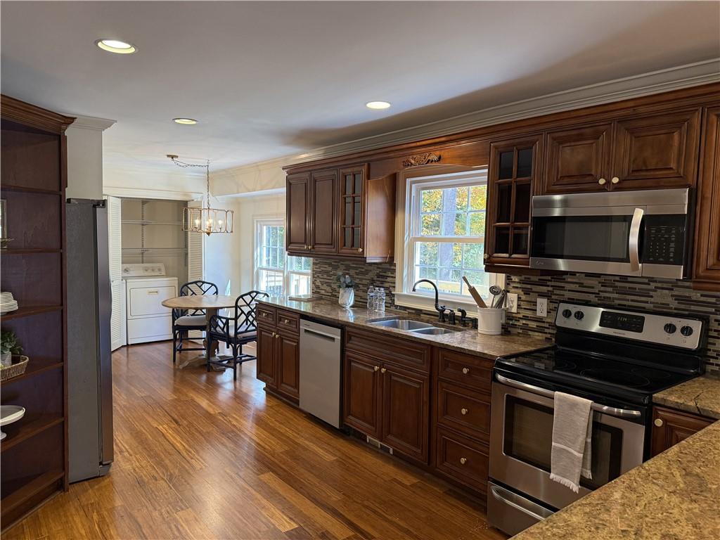 1610 Old Mill Crossing Northeast Marietta, GA 30062 - Photo 20 of 55 a kitchen with stainless steel appliances granite countertop a stove top oven a sink dishwasher a dining table and chairs with wooden floor