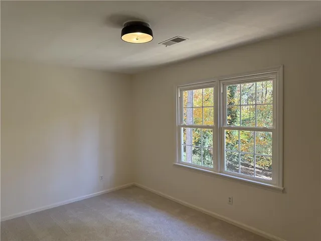an empty room with a wooden floor and window