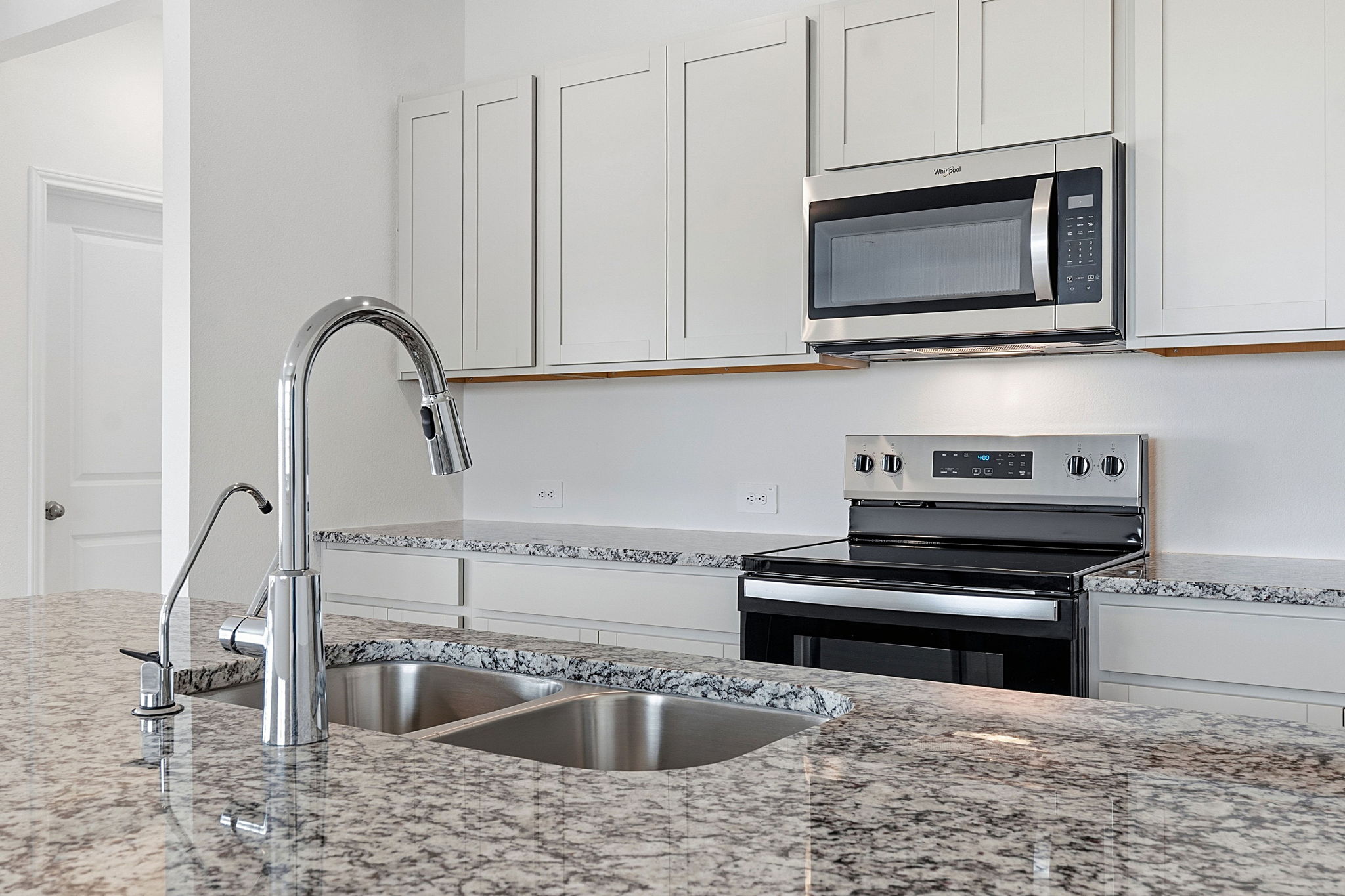 164 Cinnabar Lane, Unit 5 Kyle, TX 78640 - Photo 8 of 21 Kitchen featuring granite countertops, stainless steel appliances, a double basin sink with a gooseneck faucet, light cabinetry, and an electric range