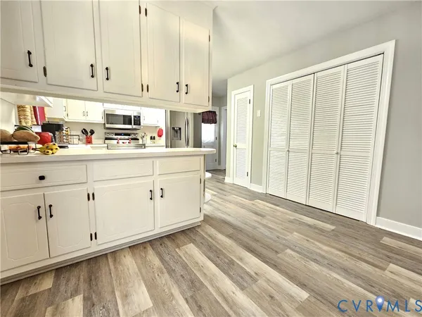 a kitchen with granite countertop white cabinets and stainless steel appliances