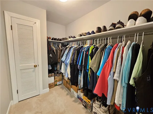 a view of walk in closet with clothes and shoes