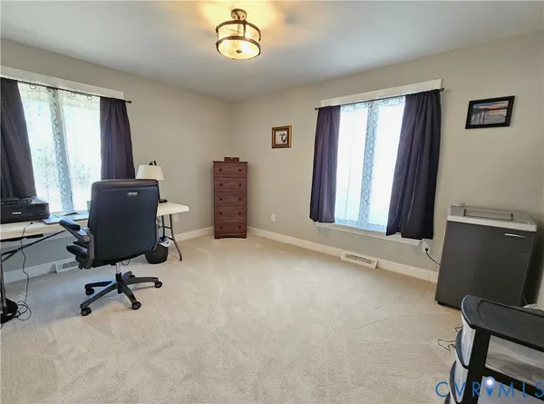 a view of a workspace with furniture and a window