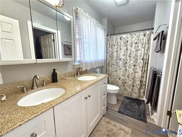 a bathroom with a granite countertop sink toilet and shower