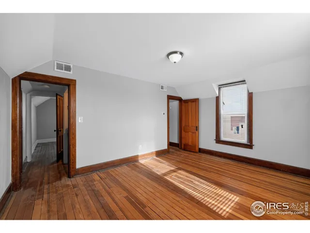 a view of an empty room with wooden floor