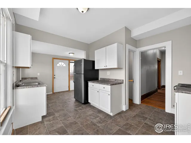 a kitchen with refrigerator and cabinets