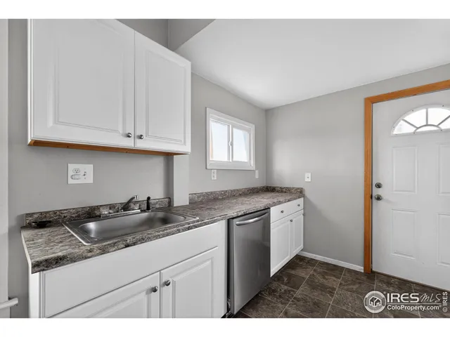 a kitchen with granite countertop a sink and cabinets