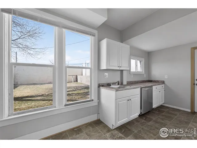 a kitchen with a stove a sink and a wooden cabinets