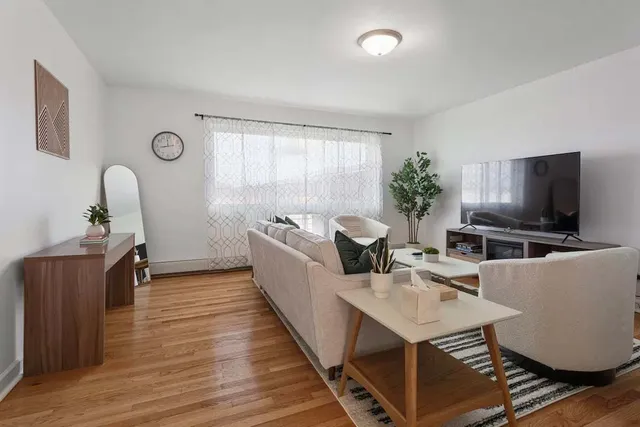 a living room with furniture a flat screen tv and a window