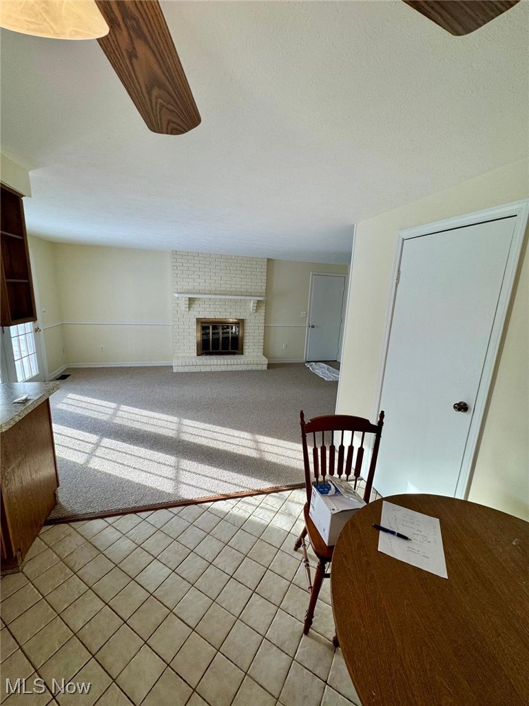 17073 Drake Road Strongsville, OH 44136 - Photo 17 of 50 Unfurnished living room featuring a fireplace, light carpet, and light tile patterned flooring