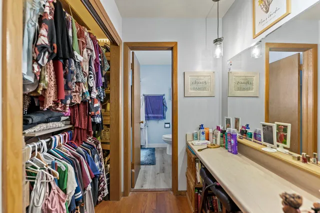 a view of walk in closet with clothes and shoes