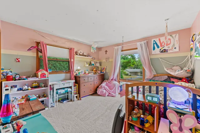 a bedroom with furniture a baby crib and a wooden floor