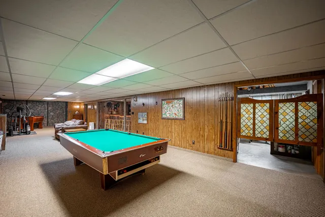a room with pool table and windows