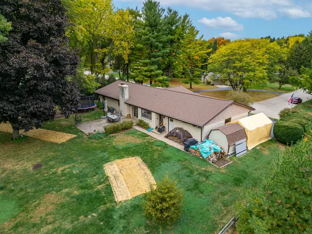 a aerial view of a house with table and chairs in a yard