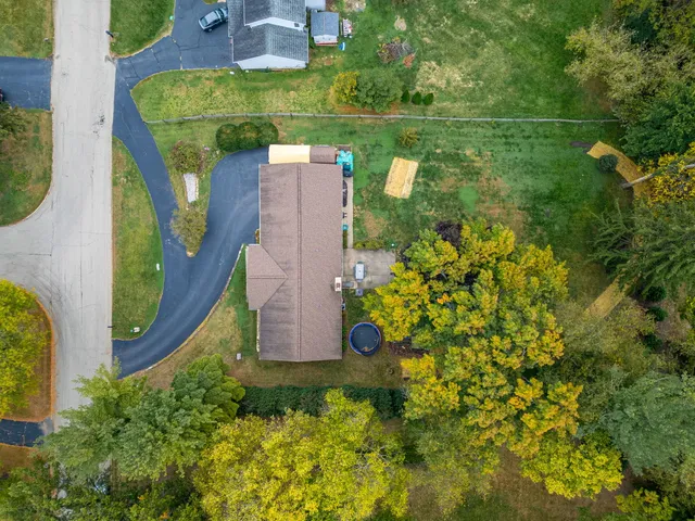 an aerial view of residential houses with outdoor space and trees