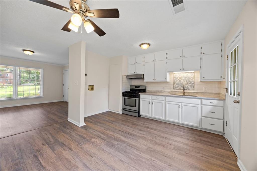 135 East Hill Street, Unit 22 Decatur, GA 30030 - Photo 13 of 18 a kitchen with a refrigerator a stove top oven a sink and dishwasher with wooden floor