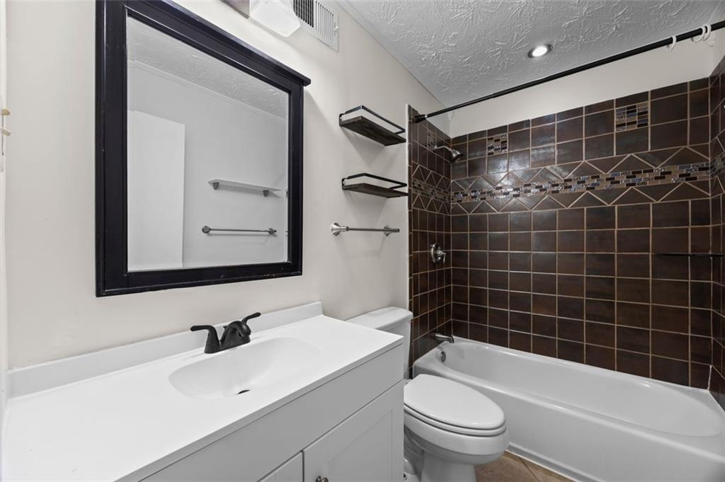 135 East Hill Street, Unit 22 Decatur, GA 30030 - Photo 15 of 18 a bathroom with a bathtub shower sink vanity and toilet
